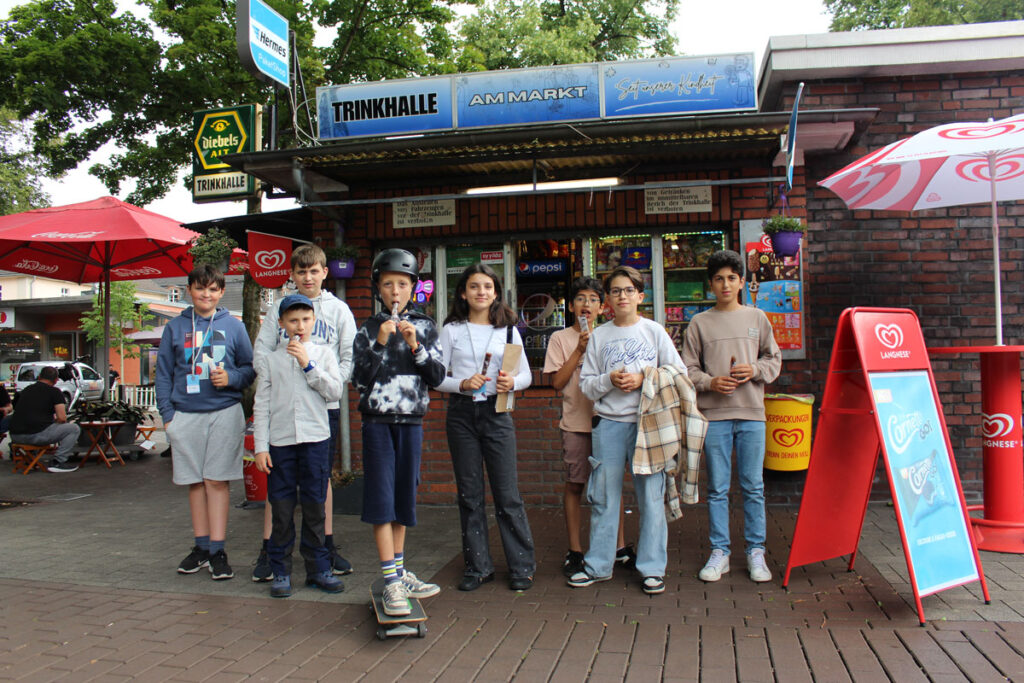 Die Film-Crew mit Wassereis vorm Kiosk am Lohberger Marktplatz